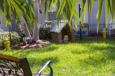 a yard with a fence and a chair in the grass at Richard's Pet Friendly Motel in Hollywood