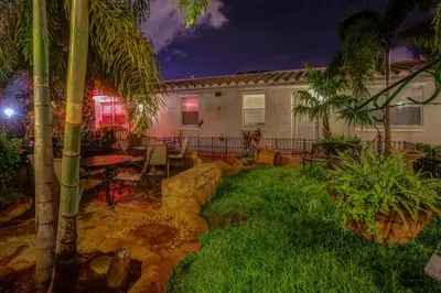 a backyard with a table and chairs and a house at Richard's Pet Friendly Motel in Hollywood