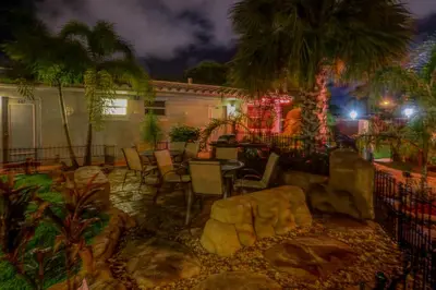 a patio with a table and chairs and palm trees at Richard's Pet Friendly Motel in Hollywood