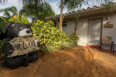 a statue of a bear holding a welcome sign at Richard's Pet Friendly Motel in Hollywood