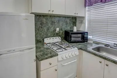 a kitchen with a stove top oven next to a microwave at Richard's Pet Friendly Motel in Hollywood