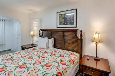 a bedroom with a bed with a floral bedspread and two lamps at Richard's Motel Courtyard in Hollywood