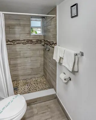 a bathroom with a shower and a toilet in it at Richard's Motel Courtyard in Hollywood
