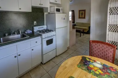 a kitchen with a stove and a sink and a table at Richard's Motel Courtyard in Hollywood