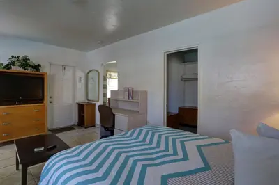 a bedroom with a bed and a flat screen tv at Richard's Motel Courtyard in Hollywood
