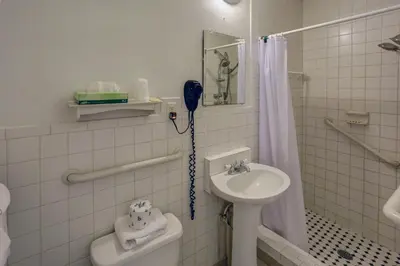 a white bathroom with a sink and a shower at Richard's Motel Studios in Hollywood