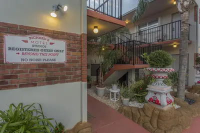 a sign in front of a building with a plant at Richard's Motel Studios in Hollywood