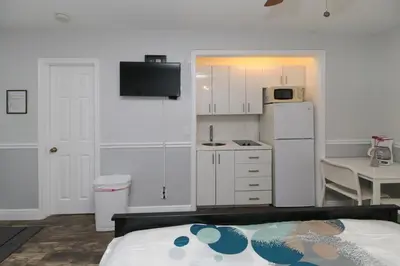a kitchen with a white refrigerator and a table with a chair at The Dolphin Hollywood in Hollywood
