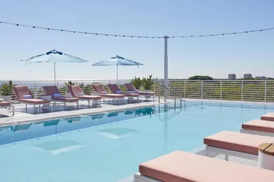 a swimming pool with chairs and umbrellas at Mr. C Miami - Coconut Grove in Miami
