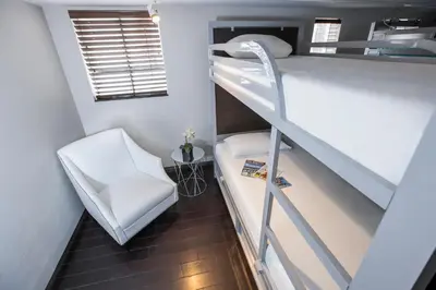 a small room with a bunk bed and a chair at Posh South Beach in Miami Beach