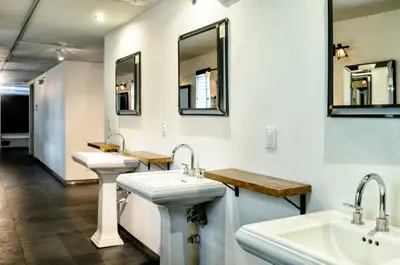 a bathroom with two sinks and two mirrors at Posh South Beach in Miami Beach