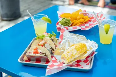 two trays of food on a blue table with drinks at Posh South Beach in Miami Beach