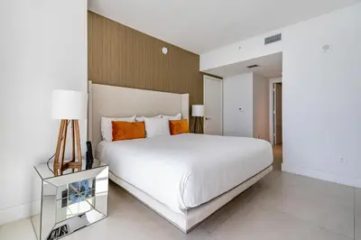 a bedroom with a large white bed with orange pillows at Private Ocean Condos at Hyde Beach Resort & Residences in Hollywood