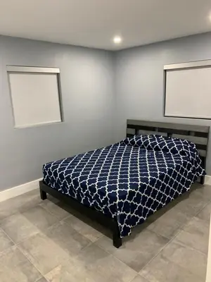 a bed in a room with two pictures on the wall at waterfront lake Hollywood hard rock Airport in Dania Beach