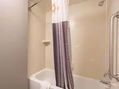 a bathroom with a shower curtain next to a bath tub at La Quinta by Wyndham Plantation at SW 6th St in Plantation