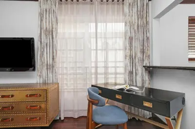 a bedroom with a desk and a chair and a dresser at Lincoln Arms Suites in Miami Beach