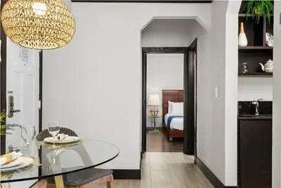 a dining room with a glass table and a bedroom at Lincoln Arms Suites in Miami Beach