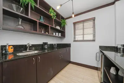 a kitchen with dark brown cabinets and a sink at Lincoln Arms Suites in Miami Beach