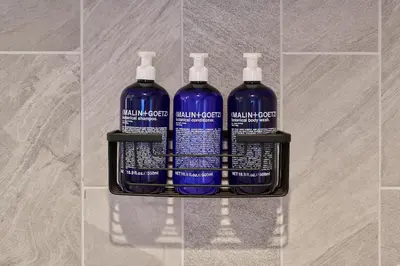 four bottles of water on a shelf in a bathroom at Hotel Greystone - Adults Only in Miami Beach