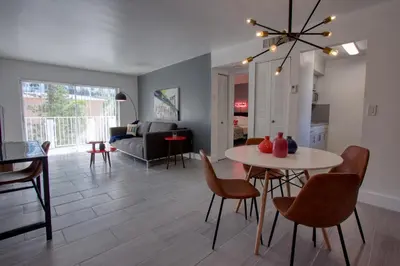 a living room with a table and chairs and a couch at 23 Palms Suites - Midtown Wynwood in Miami