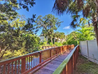 a wooden walkway with trees and a house in the background at Flamingo Place - One block to Lauderdale Marine Center - 3 bedroom - 2 bath - King bed in Fort Lauderdale