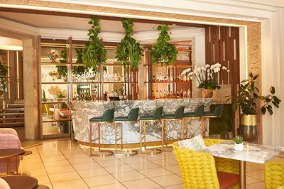 a restaurant with a bar with green chairs at Lennox Miami Beach in Miami Beach