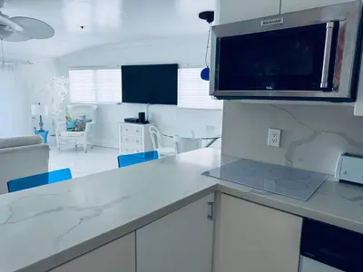 a kitchen with a counter top with a microwave at Sunrise Penthouse ocean view terrace beach few steps away SOBE in Miami Beach