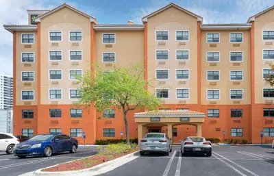 a large building with cars parked in a parking lot at Extended Stay America Premier Suites - Miami - Downtown Brickell - Cruise Port in Miami