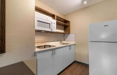 a kitchen with white cabinets and a microwave and a refrigerator at Extended Stay America Premier Suites - Miami - Airport - Doral - 25th Street in Miami