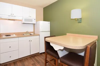 a small kitchen with a table and a refrigerator at Extended Stay America Suites - Fort Lauderdale - Davie in Davie