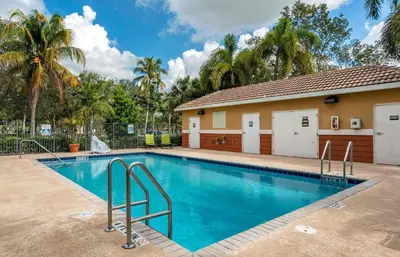 a swimming pool in front of a house at Extended Stay America Suites - Fort Lauderdale - Plantation in Plantation
