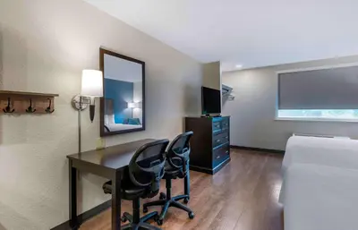 a hotel room with a desk and a bed and a bedroom at Extended Stay America Premier Suites - Miami - Coral Gables in Miami