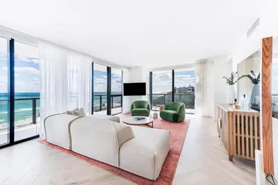 a living room with a white couch and large windows at W South Beach in Miami Beach