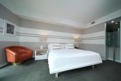 a bedroom with a white bed and a chair at The Local House in Miami Beach