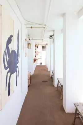 a corridor in an art gallery with benches at The Local House in Miami Beach