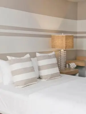 a bedroom with a white bed with pillows and a lamp at The Local House in Miami Beach