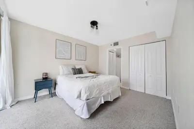 a white bedroom with a bed and a blue table at Great 2 Bedrooms in Brickell in Miami