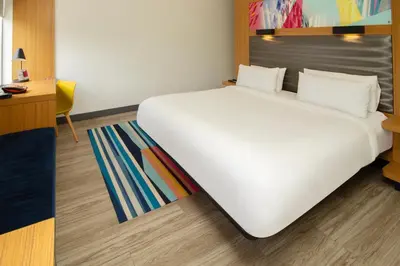 a large white bed in a room with a desk at Aloft Miami Doral in Miami