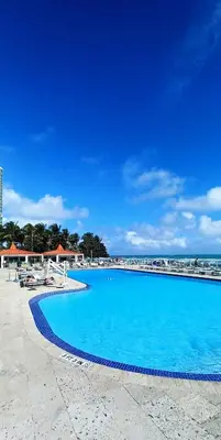 a large blue swimming pool next to the ocean at Miami Direct Access to the beach in Miami Beach