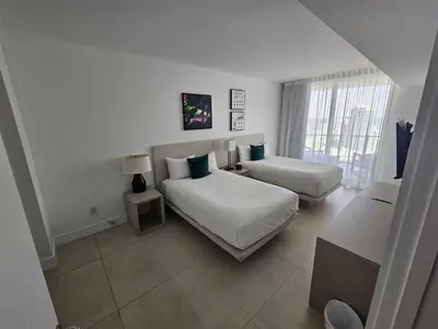 a white bedroom with two beds and a window at Lyfe-3308 in Hollywood
