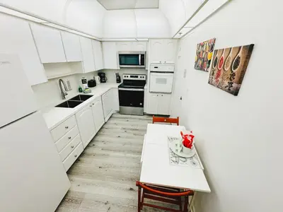 a kitchen with white cabinets and a white table at Miami Hollywood Condo With Pool and Partial Ocean View 003-21mar in Hollywood