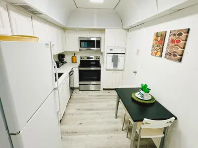 a white kitchen with a table and a refrigerator at Miami Hollywood Condo for 4 People 001-21vic in Hollywood
