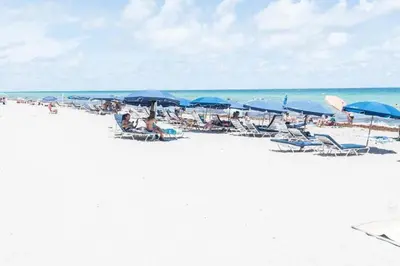 a group of people sitting on a beach with umbrellas at Miami Hollywood Condo for 4 People 001-21vic in Hollywood