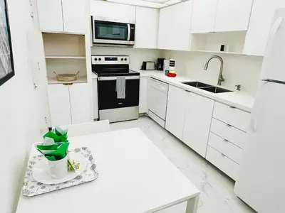 a kitchen with white cabinets and a white counter top at Hallandale Condo, Partial Ocean View Direct Beach and Pool Access Hollywood Beach in Hollywood