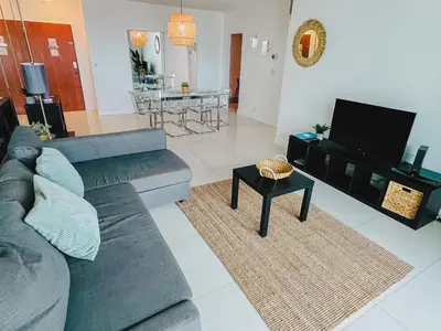 a living room with a couch and a tv at Hallandale Condo, Partial Ocean View Direct Beach and Pool Access Hollywood Beach in Hollywood