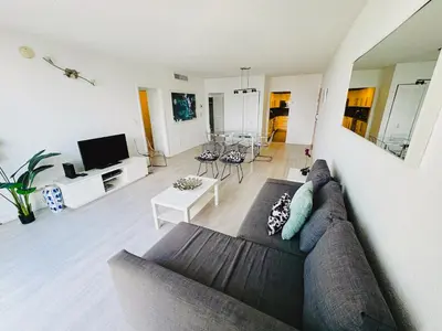 a living room with a couch and a table at Hallandale Condo, Partial Ocean View Direct Beach and Pool Access Hollywood Beach in Hollywood