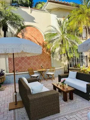 a patio with two couches and an umbrella at La Casa Hotel in Fort Lauderdale