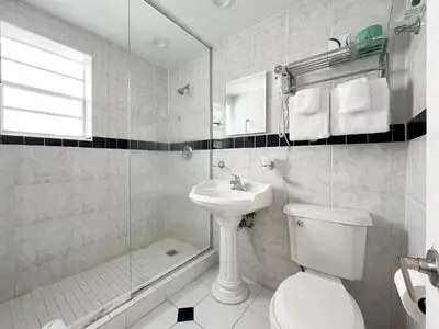 a bathroom with a toilet and a sink and a shower at La Casa Hotel in Fort Lauderdale