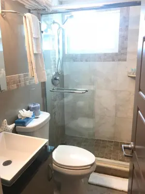 a bathroom with a shower and a toilet and a sink at Caribbean Resort Suites in Hollywood