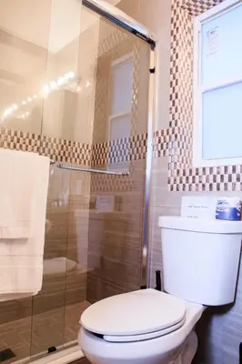 a bathroom with a toilet and a glass shower at Caribbean Resort Suites in Hollywood